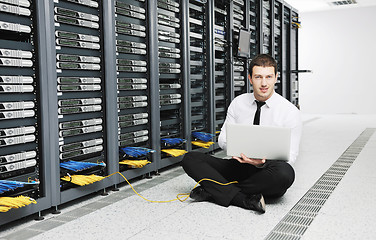 Image showing businessman with laptop in network server room