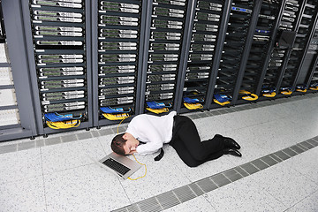 Image showing businessman with laptop in network server room