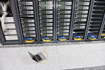 Image showing businessman with laptop in network server room