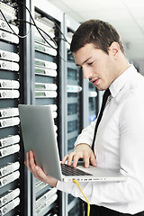 Image showing businessman with laptop in network server room