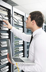 Image showing businessman with laptop in network server room