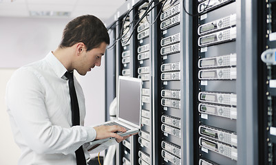 Image showing businessman with laptop in network server room