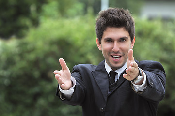 Image showing Young caucasian business man in a suite, pointing at camera to y