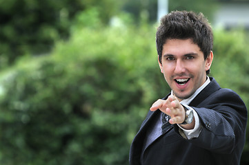 Image showing Young caucasian business man in a suite, pointing at camera to y