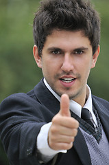 Image showing Young caucasian business man in a suite, pointing at camera to y