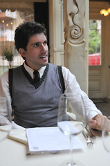 Image showing Young man sitting and waiting food at stylish restaurant