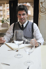 Image showing Young man sitting and waiting food at stylish restaurant