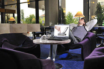 Image showing Happy man sitting and working on laptop