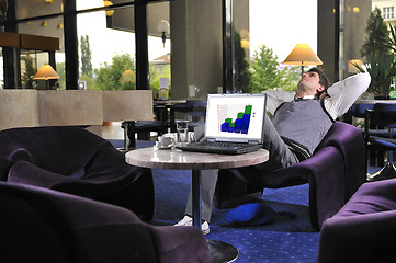 Image showing Happy man sitting and working on laptop