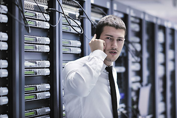 Image showing it engeneer talking by phone at network room 