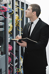 Image showing businessman withnotebook in network server room