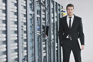 Image showing businessman with laptop in network server room