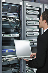 Image showing businessman with laptop in network server room