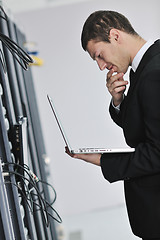 Image showing businessman with laptop in network server room