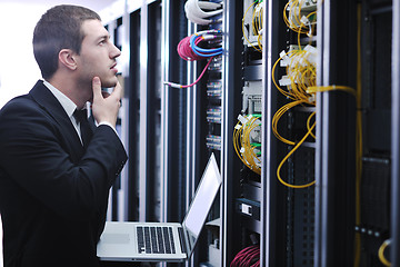 Image showing businessman with laptop in network server room