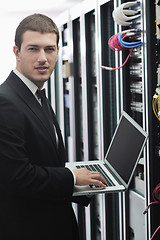 Image showing businessman with laptop in network server room