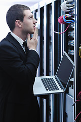 Image showing businessman with laptop in network server room