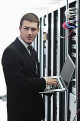 Image showing businessman with laptop in network server room