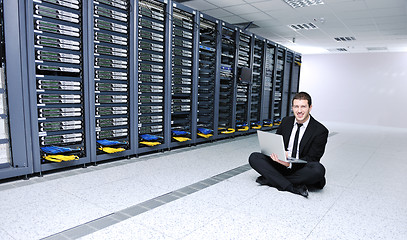 Image showing businessman with laptop in network server room