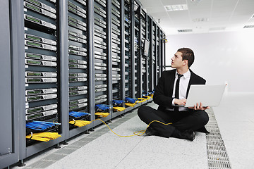 Image showing businessman with laptop in network server room