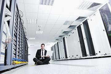 Image showing businessman with laptop in network server room