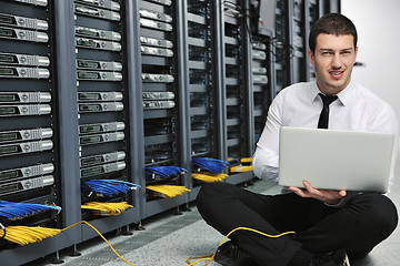 Image showing businessman with laptop in network server room