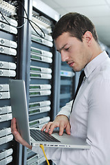 Image showing businessman with laptop in network server room