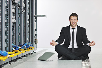 Image showing business man practice yoga at network server room