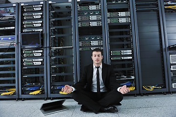 Image showing business man practice yoga at network server room