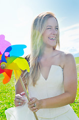 Image showing beautiful bride outdoor with colorful windmill toy