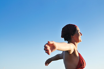 Image showing happy girl spreading hands and enjoy in sunlight