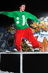 Image showing freestyle snowboarder jump in air at night