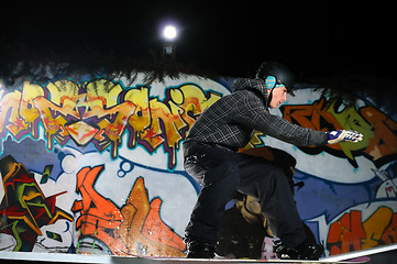 Image showing freestyle snowboarder jump in air at night