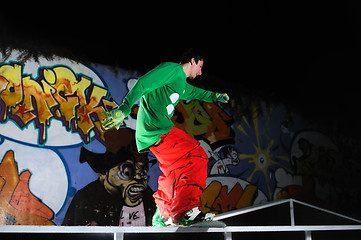 Image showing freestyle snowboarder jump in air at night