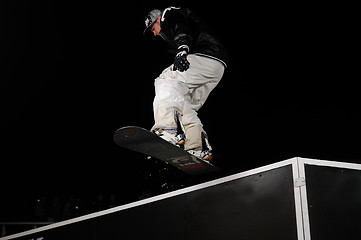 Image showing freestyle snowboarder jump in air at night