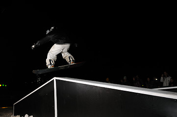 Image showing freestyle snowboarder jump in air at night