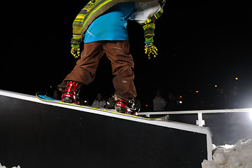 Image showing freestyle snowboarder jump in air at night