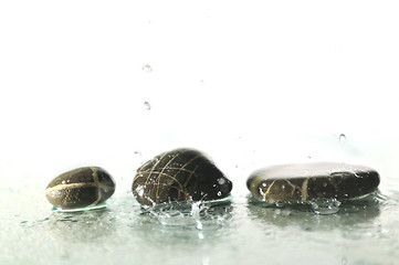 Image showing isolated wet zen stones with splashing  water drops