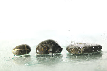 Image showing isolated wet zen stones with splashing  water drops