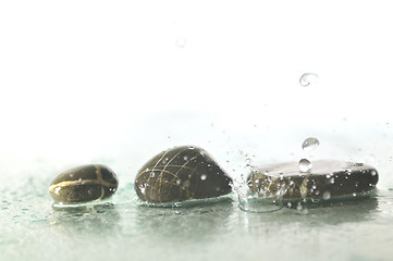 Image showing isolated wet zen stones with splashing  water drops