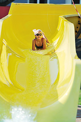 Image showing girl have fun  on water slide at outdoor swimming pool