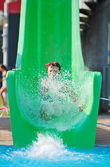 Image showing girl have fun  on water slide at outdoor swimming pool