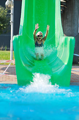 Image showing girl have fun  on water slide at outdoor swimming pool