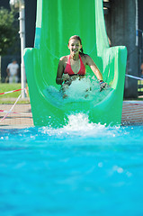 Image showing girl have fun  on water slide at outdoor swimming pool