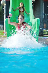 Image showing girl have fun  on water slide at outdoor swimming pool