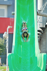 Image showing girl have fun  on water slide at outdoor swimming pool