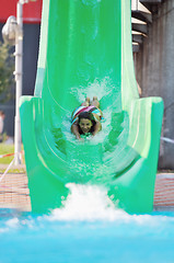 Image showing girl have fun  on water slide at outdoor swimming pool