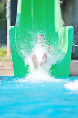 Image showing girl have fun  on water slide at outdoor swimming pool