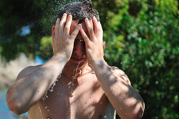 Image showing young man relaxing under shower