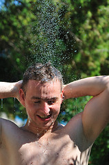 Image showing young man relaxing under shower